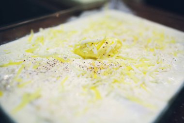 Plaka üzerinde beyaz sos dökme pişmiş spagetti