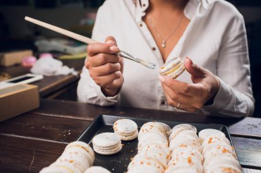 Macaroons yapma işlemi. Sığ odak. gıda boya ile fırça