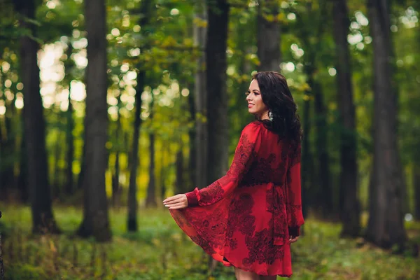 Happy beautiful young woman dancing of freedom in summer park with trees in background. Summer Palace park.