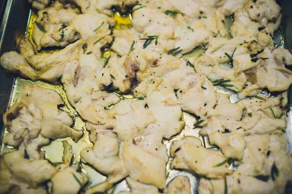 Diced healthy lean white meat chicken pieces on chopping board with fresh herbs ready to be used in preparation evening meal