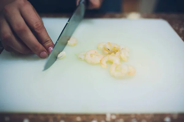 Langostinos a la parrilla con cuchillo sobre tabla blanca para cocinar . —  Fotos de Stock