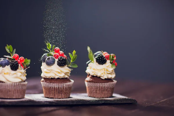 Muffin dekorace. Bez moučkového cukru. žena cukrář vyvolá prášek — Stock fotografie