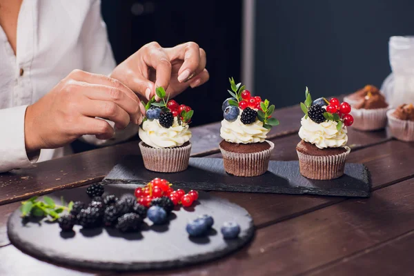 Confiseur décorant cupcake supérieur avec groseille glacée avant de servir — Photo