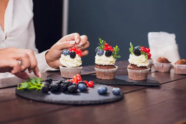 Ζαχαροπλάστης διακόσμηση κορυφαία cupcake με τζάμια σταφίδα πριν το σερβίρισμα — Φωτογραφία Αρχείου