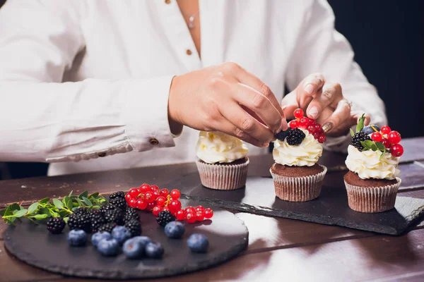 Ζαχαροπλάστης διακόσμηση κορυφαία cupcake με τζάμια σταφίδα πριν το σερβίρισμα — Φωτογραφία Αρχείου