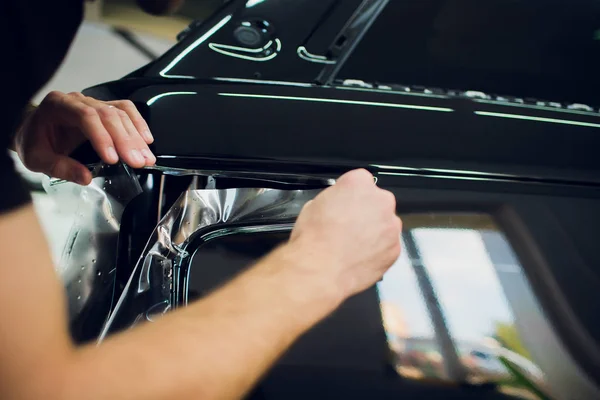 Çalışan eller yükler araba boya koruma film sarma. — Stok fotoğraf