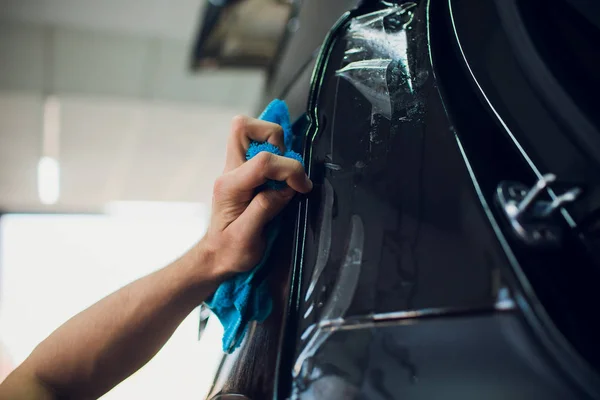 Mani lavoratore installa pellicola di protezione vernice auto avvolgere . — Foto Stock