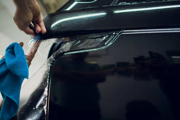 Munkás kéz telepíti, autó paint védelem film wrap. — Stock Fotó