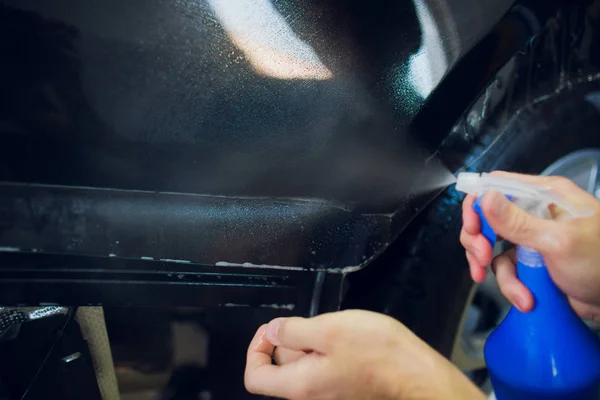Manos de trabajador instala película de protección de pintura de coche envoltura . —  Fotos de Stock