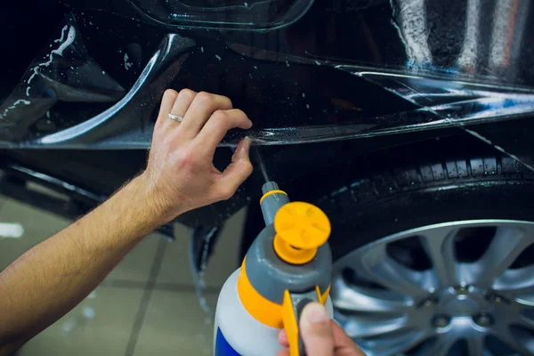 Manos de trabajador instala película de protección de pintura de coche envoltura . —  Fotos de Stock