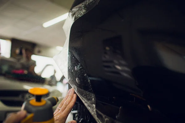 Pracovní ruce nainstaluje car paint ochrany fólie. — Stock fotografie