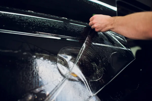 Werknemer handen installeert auto verf bescherming film wrap. — Stockfoto