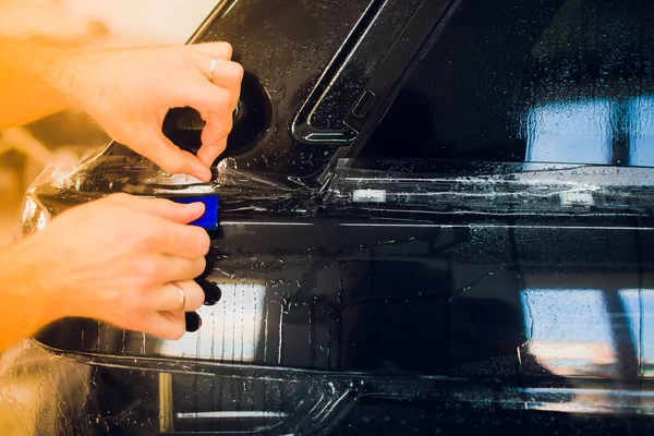 Руки працівника встановлюють захисну плівку для фарби автомобіля . — стокове фото