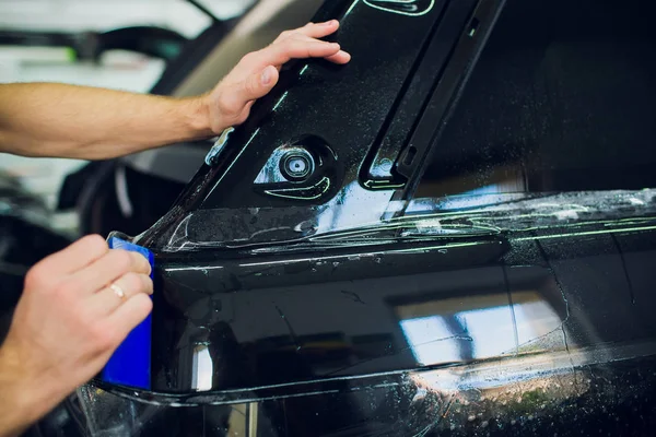 Arbetaren händer installerar bil paint protection film wrap. — Stockfoto