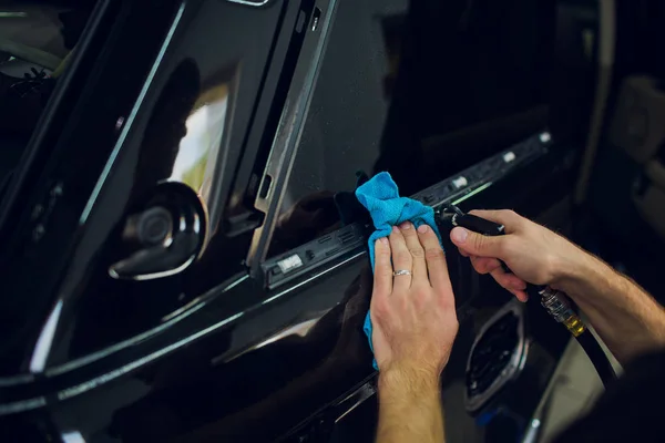 Installation d'un film auto-protecteur, le spécialiste se débarrasse de l'humidité et du liquide, en soufflant de l'air — Photo