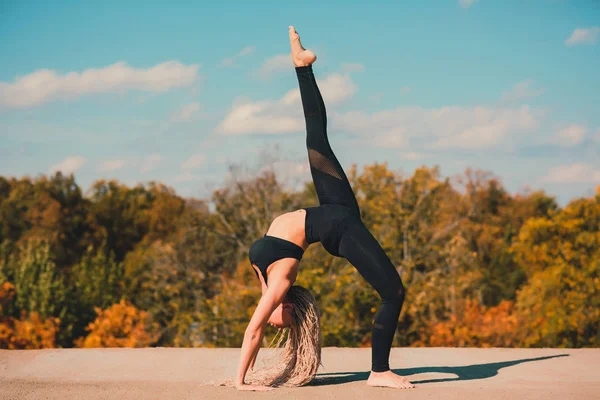 Donna che fa yoga sul tetto di un grattacielo nella grande città . — Foto Stock