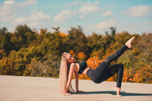 Donna che fa yoga sul tetto di un grattacielo nella grande città . — Foto Stock