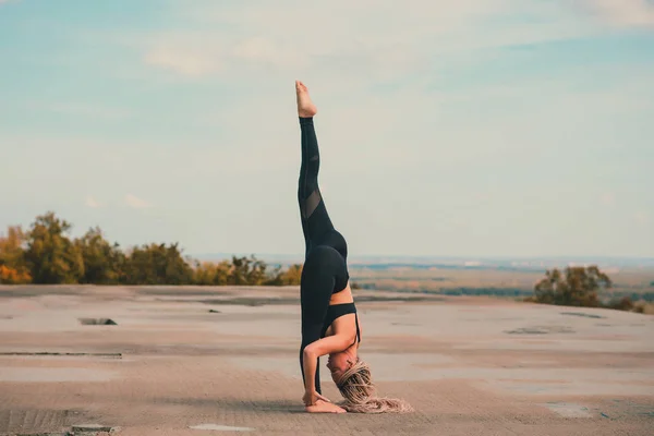 Donna che fa yoga sul tetto di un grattacielo nella grande città . — Foto Stock