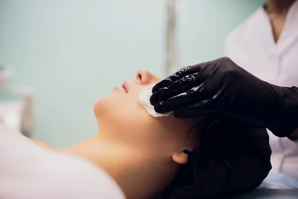 Витерти стерильною серветкою обличчя. Молода жінка отримує процедури в салонах краси . — стокове фото