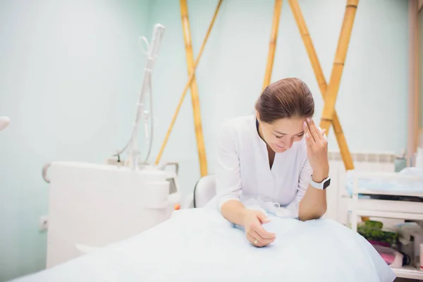 Retrato jovem esteticista feminina em camiseta turquesa esperando cliente no local de trabalho da clínica de cosmetologia . — Fotografia de Stock