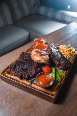 Izgara biftek sebze ve otlar ile servis peçete ile dekore edilmiş rustik ahşap tahta üzerinde