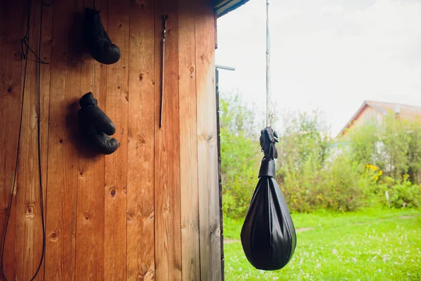 Un grand sac de boxe en cuir est accroché au terrain de sport de rue — Photo