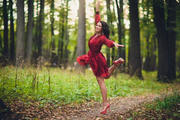 Щасливі красива молода жінка танці свободи в літній парк з дерев у фоновому режимі. Літній парк палацу. — стокове фото