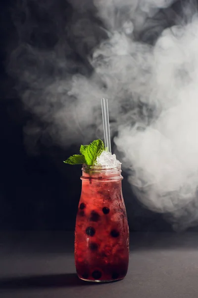Donkere en stormachtige rum cocktail met aardbei tegen achtergrond rook. — Stockfoto