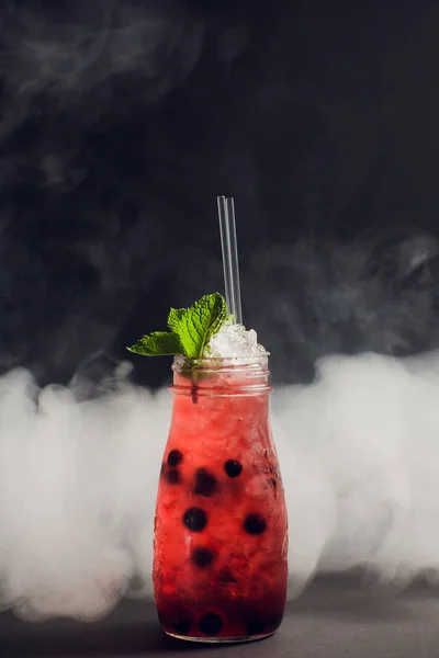 Donkere en stormachtige rum cocktail met aardbei tegen achtergrond rook. — Stockfoto