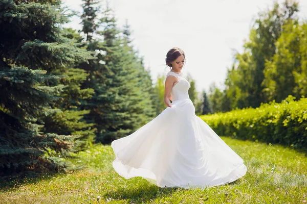 Belle mariée heureuse dansant et tournant dans le parc le jour de son mariage . — Photo