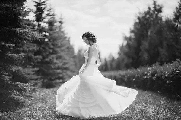 Bella sposa felice che balla e gira nel parco nel giorno del suo matrimonio . — Foto Stock