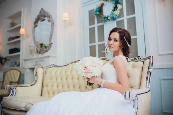 Ritratto di bella sposa felice seduta sul divano . — Foto Stock