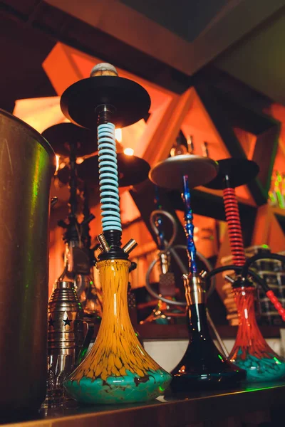 Gruppe roter Shisha-Wasserpfeifen auf Tisch im Innenraum. — Stockfoto