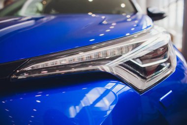 Lüks mavi araba arka planda shot Far kapatın. Modern ve pahalı spor araba konsepti