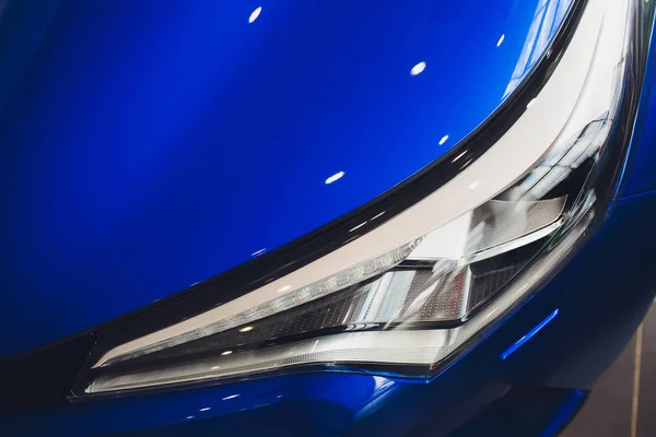 Gros plan phare dans fond de voiture de luxe bleu. Concept de voiture de sport moderne et coûteux — Photo
