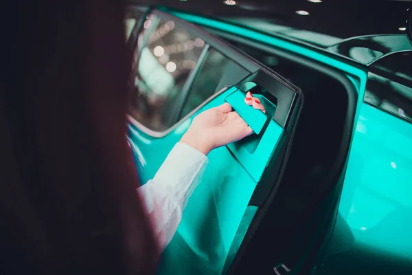 Mano femenina para insertar puerta trasera abierta coche color beige. para el transporte y la imagen del automóvil — Foto de Stock