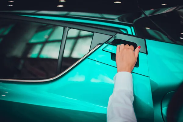 Ženská ruka pro vložení zadní dveře otevřené auto béžové barvy. pro dopravní a automobilové obraz — Stock fotografie