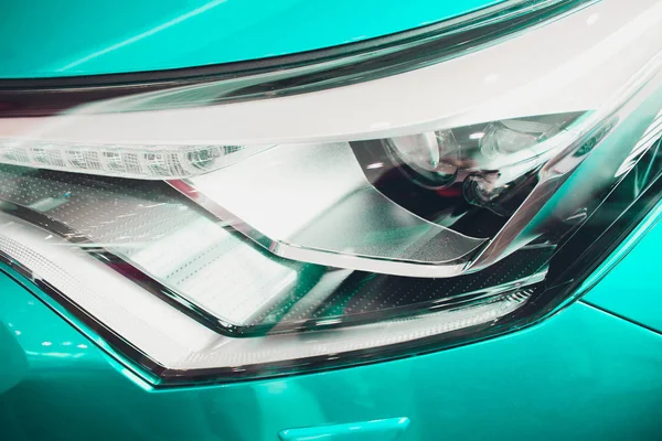 Közelről lövés fényszóró luxus bézs autó háttérben. Modern és drága sport autó fogalma — Stock Fotó