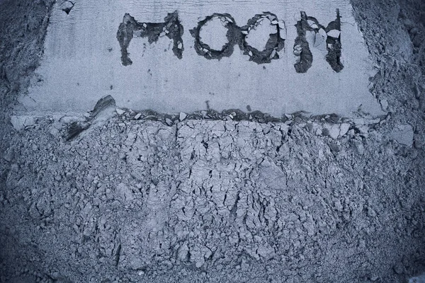 On gray moon sand is inscribed by moon. Copy space. On right is plant germ. Extraction minerals on moon. Colonization. Life on moon