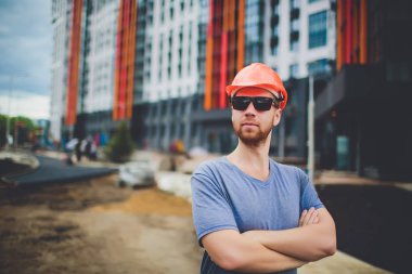 işçi ile endüstriyel duvarının yakınında Sarı kask ve kot gömlek