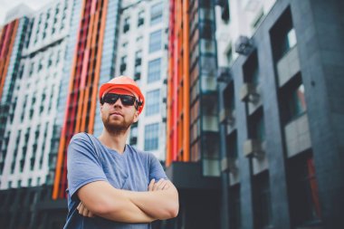 işçi ile endüstriyel duvarının yakınında Sarı kask ve kot gömlek