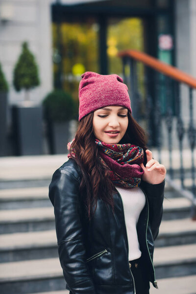 Portrait of funny young girl in the autumn weather in warm clothes and hat.