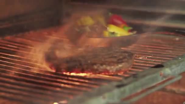 불타는 그릴에 스테이크를 굽고 선택적 인 초점으로 사격. — 비디오