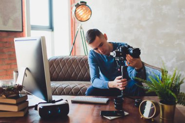 Sabitleyici kamera. bilgisayar monitörü. Genç freelancer adam laptop internet online ya da sosyal medya için video yüklemek için video düzenleme.