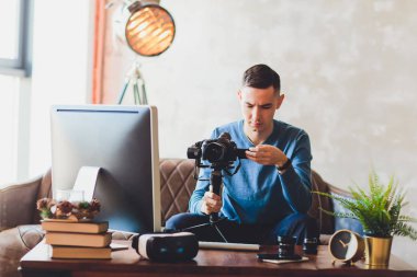 Sabitleyici kamera. bilgisayar monitörü. Genç freelancer adam laptop internet online ya da sosyal medya için video yüklemek için video düzenleme.