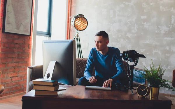 Sabitleyici kamera. bilgisayar monitörü. Genç freelancer adam laptop internet online ya da sosyal medya için video yüklemek için video düzenleme.