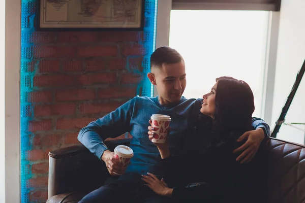 Belo casal sentado em atmosfera romântica olhando uns para os outros, falando, sorrindo e bebendo chá quente. A mulher grávida e o marido a passar tempo juntos na cozinha. Conceito de família de prática . — Fotografia de Stock