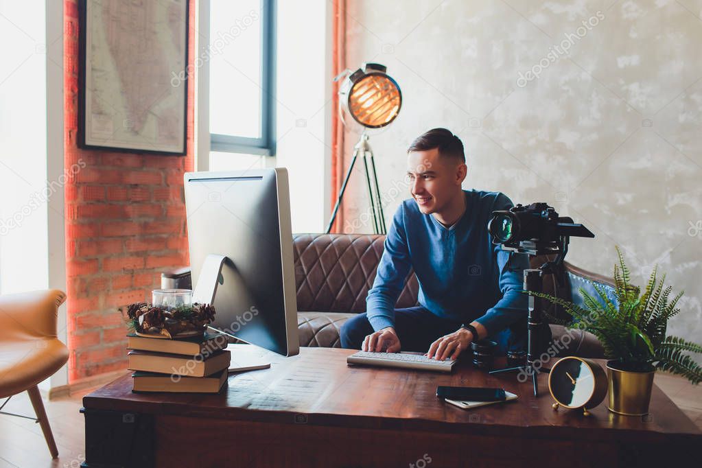 stabilizer camera. computer monitor. Young freelancer man editing video on laptop for uploading video to internet online or social media