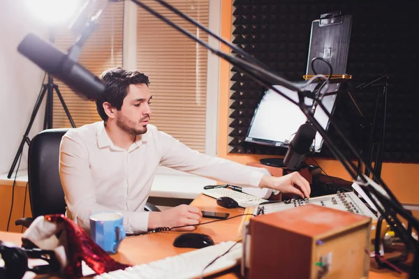 ハンサムな若いラテン男のラジオ局でノート パソコンとマイクの前に座っての肖像画. — ストック写真