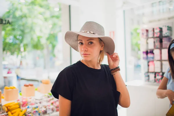 Приваблива жінка намагається на капелюсі. Щасливі літні покупки . — стокове фото